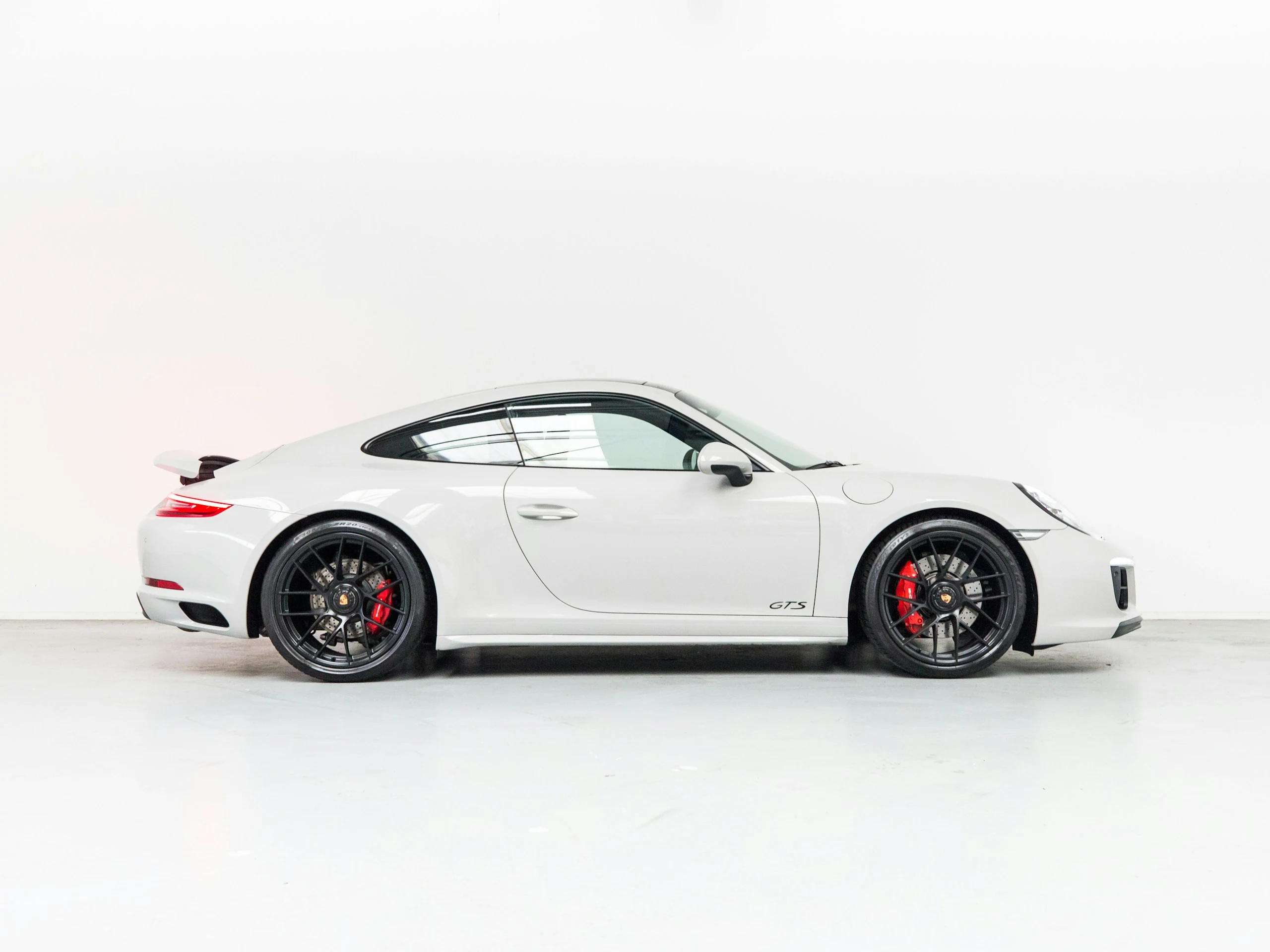 Белый Porsche 911 Carrera 4 GTS в светлой студии